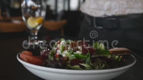 将石榴酱倒入健康的绿色沙拉中视频的预览图