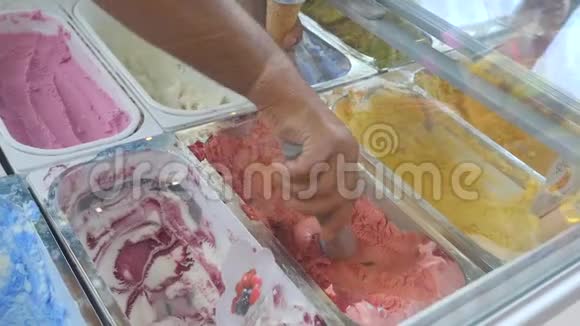 在冰淇淋店里卖冰淇淋男人把冰淇淋球放进华夫饼筒里视频的预览图