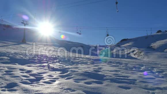 宽阔的视野移动的空滑雪电梯和一个人滑雪板从雪山背景视频的预览图