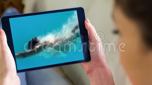数字平板屏幕显示一名女子在游泳池游泳视频的预览图