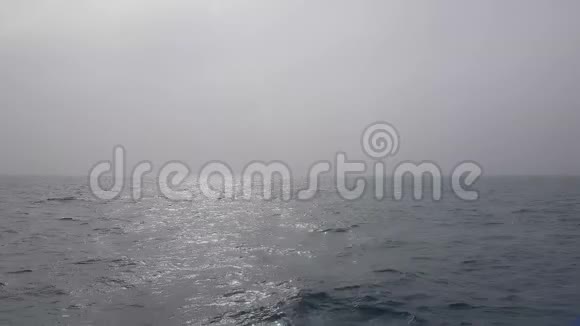 阴天时的海景海浪的太阳冲破了雾朦胧的海洋景观海洋海浪视频的预览图