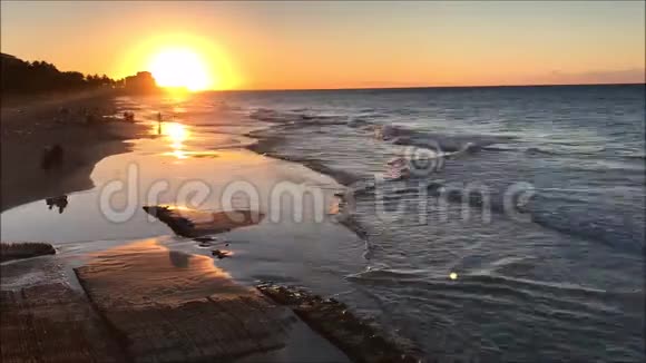 日落时分热带沙滩与人们的视频片段视频的预览图