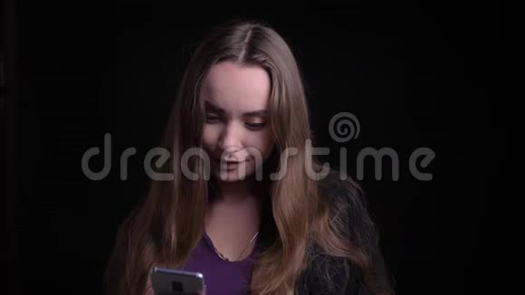 年轻迷人的白种人女性用手机特写镜头然后看着镜头开心地笑着视频的预览图