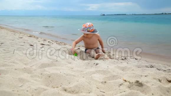 小男孩正在海边的沙滩上玩耍视频的预览图