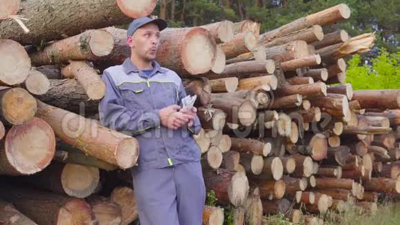 工人伐木工人或木匠在一堆木头附近有一大堆钱锯木头成功的概念视频的预览图