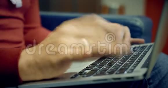 穿休闲服装的男人在笔记本电脑上工作键盘特写镜头视频的预览图