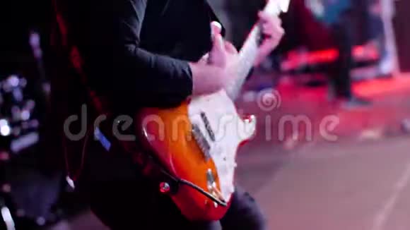吉他手在大舞台上表演快关门舞台灯光闪烁有表现力的吉他手弹弦视频的预览图