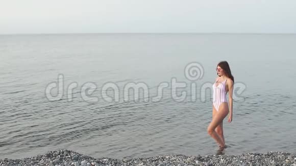 快乐的女人在海滩上戴着太阳镜在海里玩耍视频的预览图