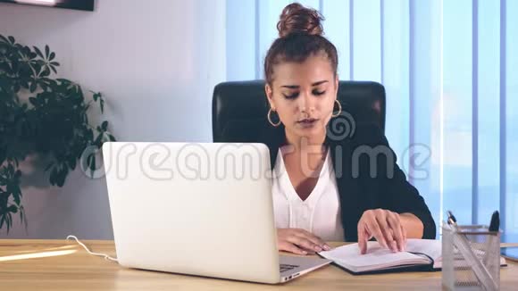 这个女孩坐在办公室时穿着时髦的衣服在阅读时打印信息视频的预览图