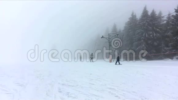 活动绳拖滑梯与滑雪者在黑暗的雪雾天在山上捷克共和国Karkonosze国家公园视频的预览图