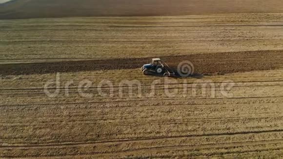 在晴朗的春天秋天的天气蓝色拖拉机培育棕壤视频的预览图