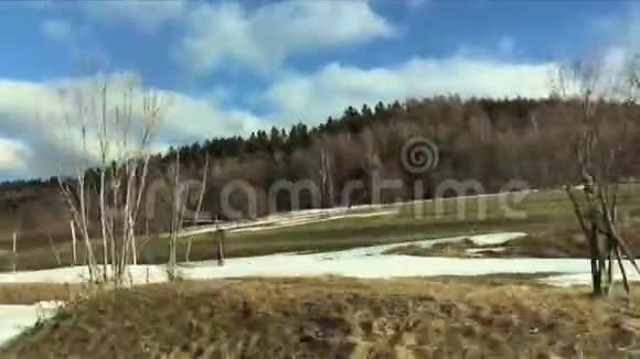 从车窗看到山景山在早春雪和绿草对蓝天视频的预览图