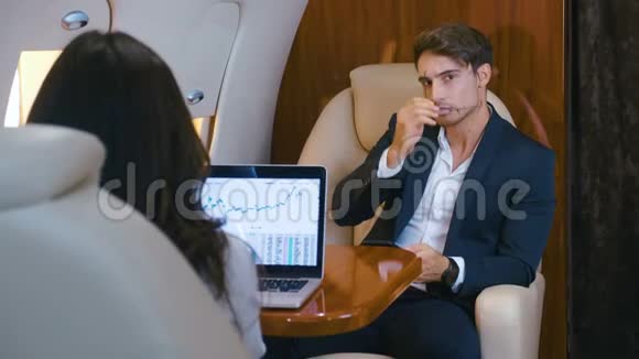 成功的商人驾驶私人飞机在笔记本电脑上工作使用智能手机商人和女商人视频的预览图