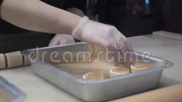 场景库克把准备好的面包和肉桂放在金属烤盘上生产肉桂卷面包制品视频的预览图