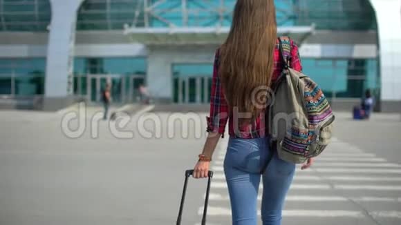 年轻男子步行到现代机场候机楼为她的航班从后面看女性旅行者特写镜头视频的预览图