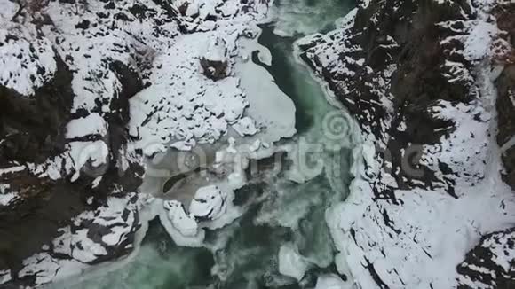 雪覆盖峡谷底部快速流动的绿松石水视频的预览图