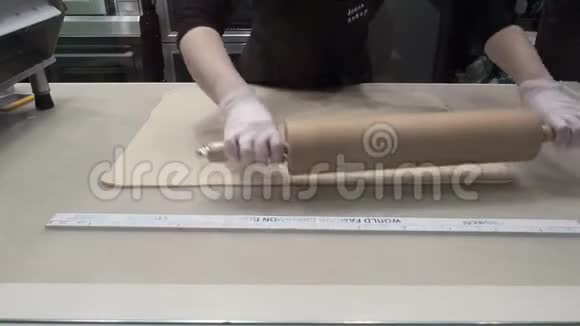 场景库克用擀面杖对面片塑造面团生产肉桂卷面包店视频的预览图