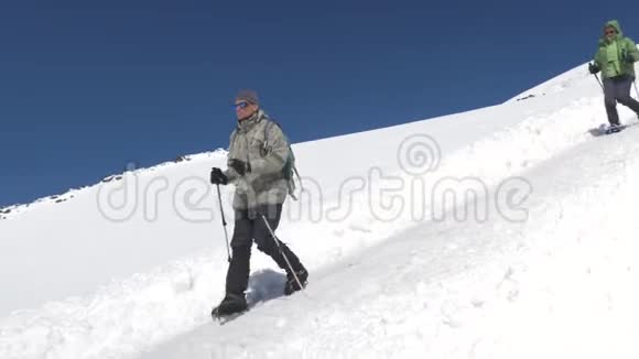 一男一女他们都是登山者沿着雪坡往下走到大本营高加索山脉视频的预览图