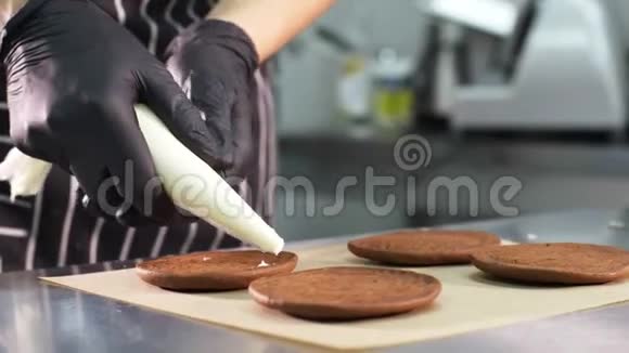 糕点厨师正在用奶油和果酱填充饼干制作小蛋糕视频的预览图