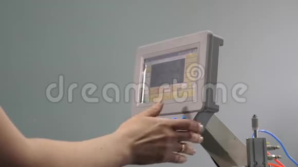 工人正在用平板电脑编程一台数控缝纫机操作人员设置数控机床视频的预览图