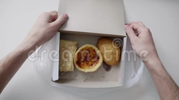 男人手拿着白色的塑料袋里面有白色的纸盒里面有蛋糕和包子视频的预览图