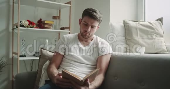 在客厅里男人坐在沙发上看书周围是现代设计视频的预览图