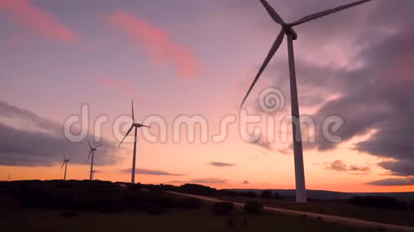 风电场上美丽的紫色夕阳山景可再生生态能源生产视频的预览图