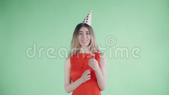 年轻女子在绿色背景下爆炸纸屑饼干视频的预览图