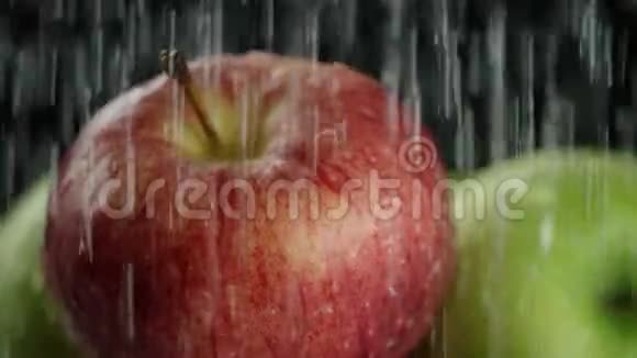 在视频中我们看到苹果水从顶部像雨一样倾泻特写黑色背景视频的预览图