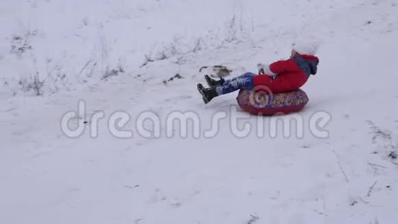 年轻女孩在油管上滑下快乐的孩子在圣诞公园玩慢动作视频的预览图