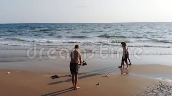 爸爸拿起相机孩子们在海滩上跑孩子视频的预览图