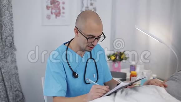 戴眼镜的男医生记录了床上病房病人的信息视频的预览图