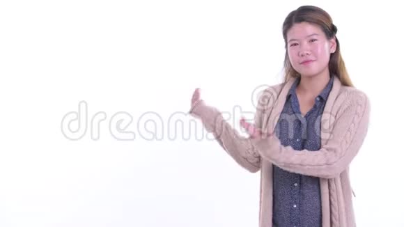 快乐的年轻亚洲女人展示了准备过冬的东西视频的预览图