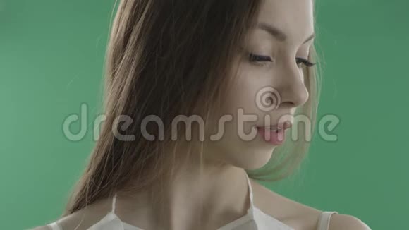 性感的年轻女人在绿色背景下咬着嘴唇视频的预览图