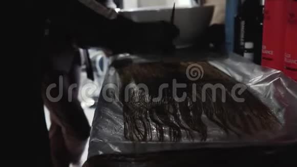 美容师彩色头发发型师做头发着色理发师双手戴着黑色手套烧烤店视频的预览图