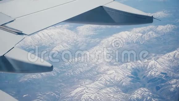 令人难以置信的视野从飞机窗口座位在飞行的中间飞行在惊人的雪山峰脊之上视频的预览图