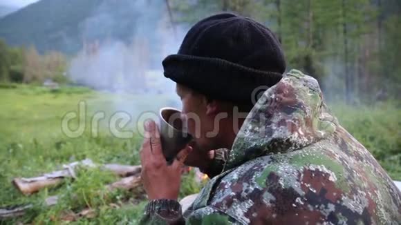 游客从火边的杯子里喝茶视频的预览图