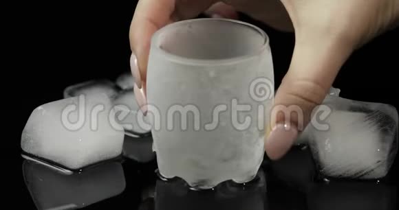 将伏特加倒入冰杯中放入黑色背景下的冰块视频的预览图