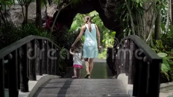 亚洲母女在桥上的公园里散步视频的预览图