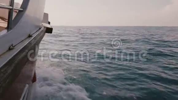 相机在游船船的右侧在深蓝色的海洋中航行在阳光明媚的日子里有惊人的泡沫白色波浪视频的预览图
