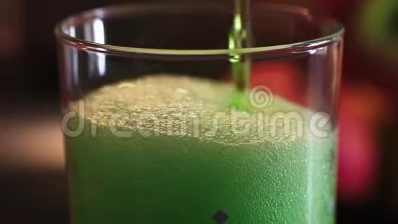 绿雌龙柠檬水倒入水玻璃有很多气泡和泡沫视频的预览图