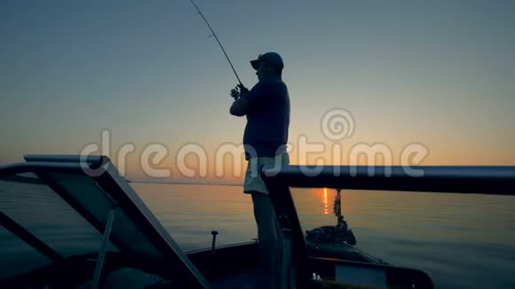 雄垂钓者正在把钓竿投进阳光明媚的湖中视频的预览图
