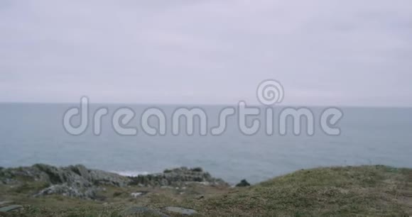 一名男子游客穿着棕色靴子在山顶海岸的特写细节他欣赏海景视频的预览图