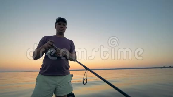 在捕鱼过程中雄性垂钓者正在钓一根钓竿的筒视频的预览图