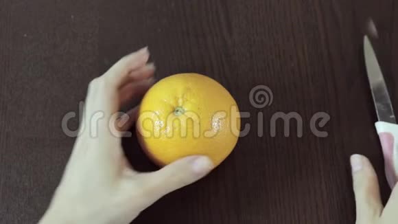 女人手在木背景上剥着橘子最简单最快的方法视频的预览图