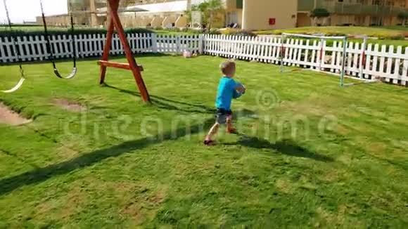 4k视频快乐的小男孩在公园的操场上跑步和打球视频的预览图