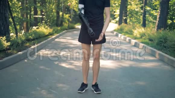 运动员穿着仿生假肢慢跑前要热身有机器人手臂的人视频的预览图