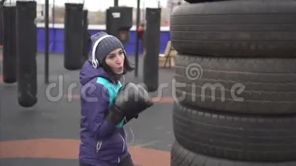 戴拳击手套的女运动员在街头训练场打梨视频的预览图