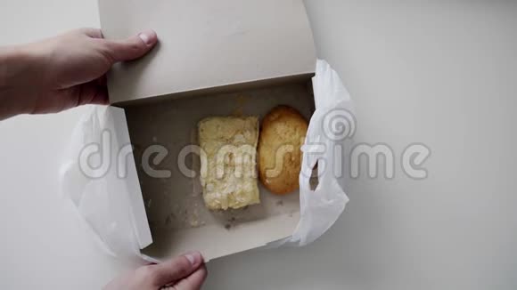 人手拿包子从白色纸盒里拿出来放在白色塑料袋里视频的预览图