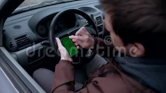 男性司机使用智能手机车里有绿色屏幕视频的预览图